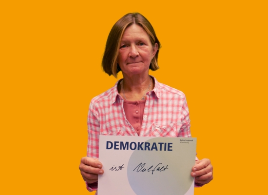 Frau mit Schild in der Hand Demokratie ist Vielfalt.