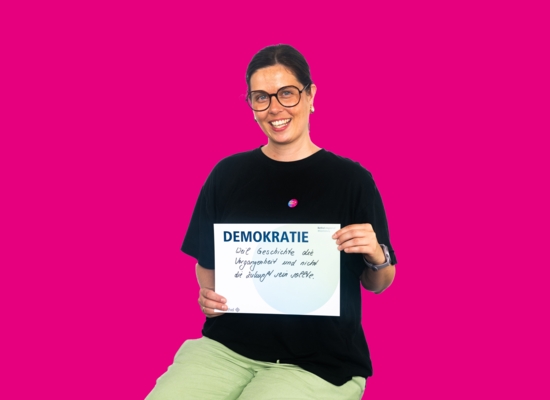 Frau mit Schild Demokratie, weil Geschichte die Vergangenheit und nicht die Zukunft sein sollte.