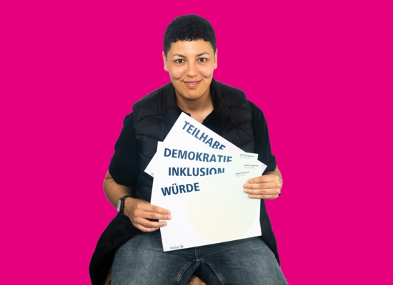 Frau mit Schildern in der Hand Teilhabe, Demokratie, Inklusion, Würde.