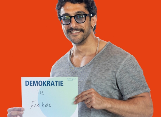 Mann mit Schild Demokratie ist Freiheit