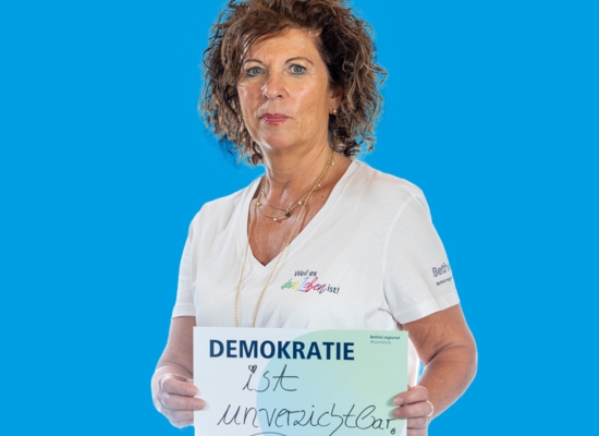 Frau mit Schild in der Hand Demokrat ist unverzichtbar.