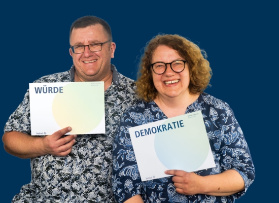 Mann und Frau mit Schildern Würde und Demokratie.