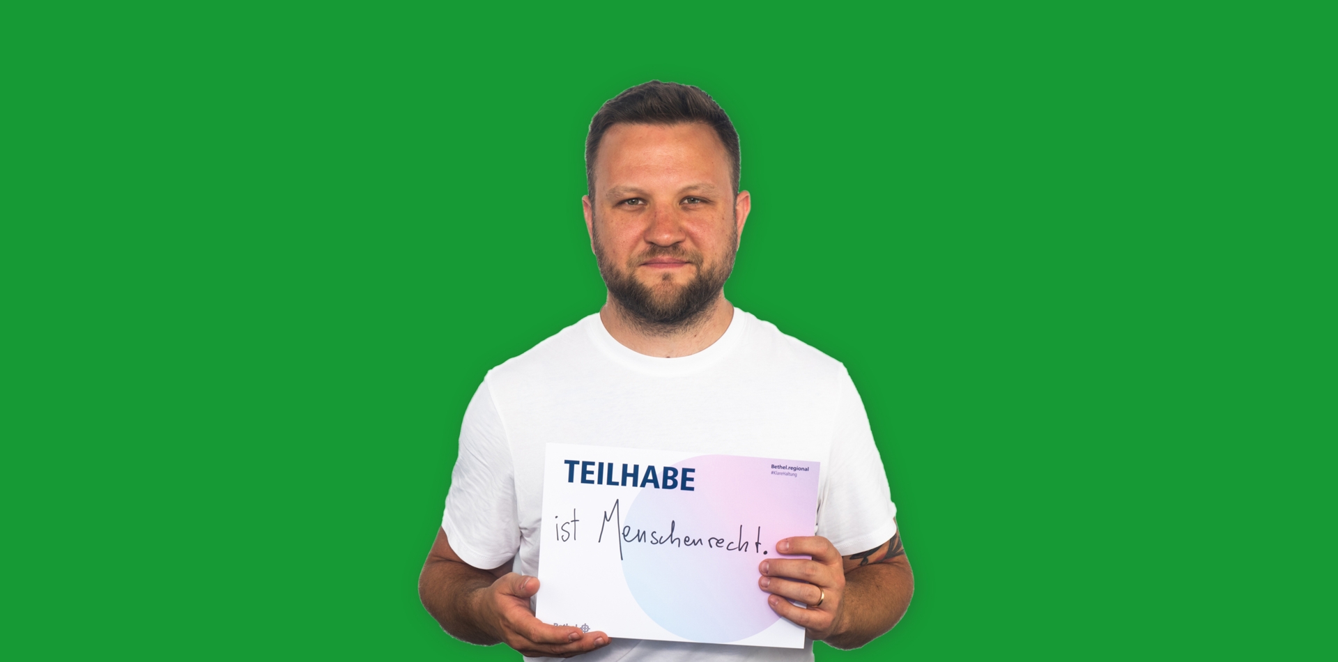 Mann mit Schild Teilhabe ist Menschenrecht