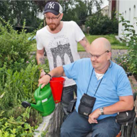 Ein Mann gießt seinen Garten in Begleitung durch das Intensiv Betreute Wohnen in Witten, das Menschen mit erworbenen Hirnschädigungen oder psychischer Behinderung unterstützt.