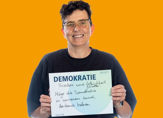 Frau mit Schild Demokratie Frieden und Gleichheit für alle! Möge die Demokratie in unserem Lan bestand haben.