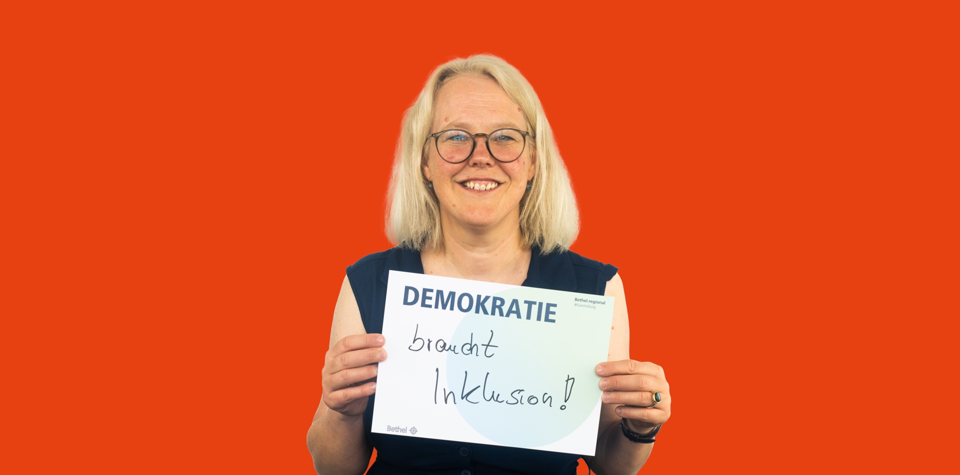 Frau mit Schild in der Hand Demokratie braucht Inklusion!