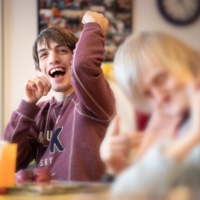 Junger Mann im Gemeinschaftsraum mit Lachen im Gesicht