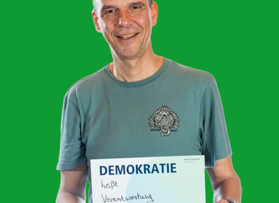 Mann mit Schild in der Hand Demokratie heißt Verantwortung übernehmen!