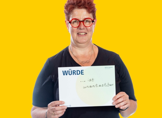 Frau mit Schild Würde ... ist unantastbar.