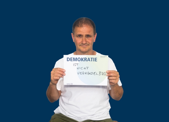 Mann mit Schild Demokratie ist nicht verhandelbar.