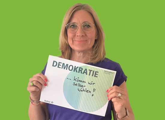 Frau mit Schild in der Hand Demokratie .... können wir selber wählen!