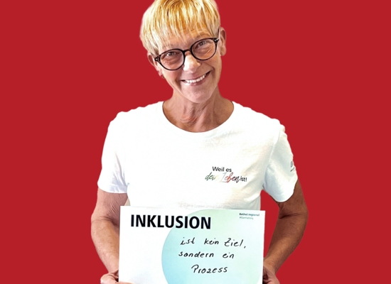 Frau mit Schild in der Hand Inklusion ist kein Ziel, sondern ein Prozess