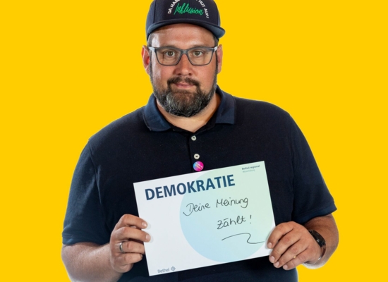 Mann mit Schild Demokratie Deine Meinung zählt!