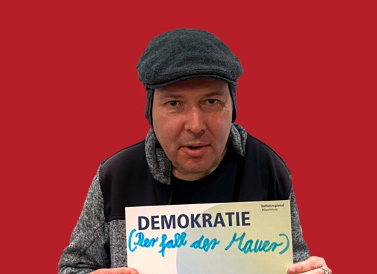 Mann mit Schild in der Hand Demokratie (Der Fall der Mauer)