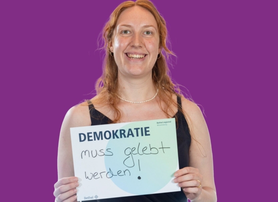 Frau mit Schild Demokratie muss gelebt werden!