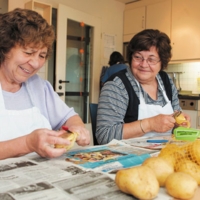 Zwei Frauen schälen Kartoffeln im Haus Lutherstraße in Lünen von Bethel.regional, das ein Angebot für Menschen mit psychischen Erkrankungen ist.